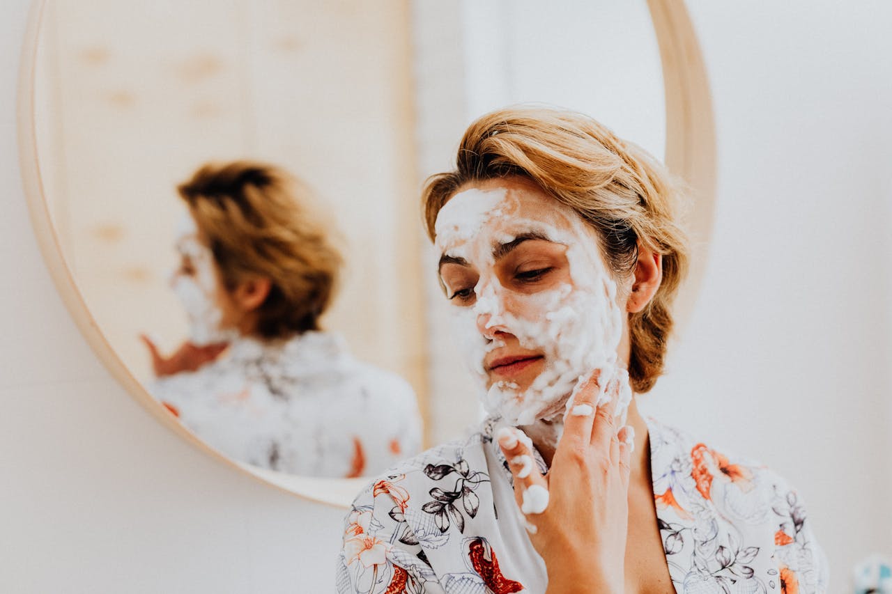 A woman enjoying a relaxing skincare routine with a facial mask in her bathroom, reflecting personal care.